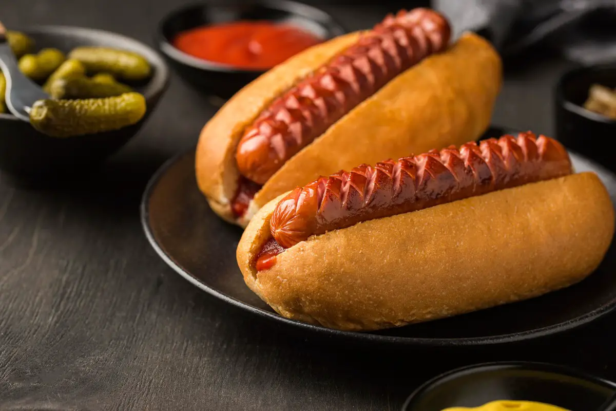 Golden-brown cheddar brats on a platter, showcasing the juicy, cheese-filled interior.