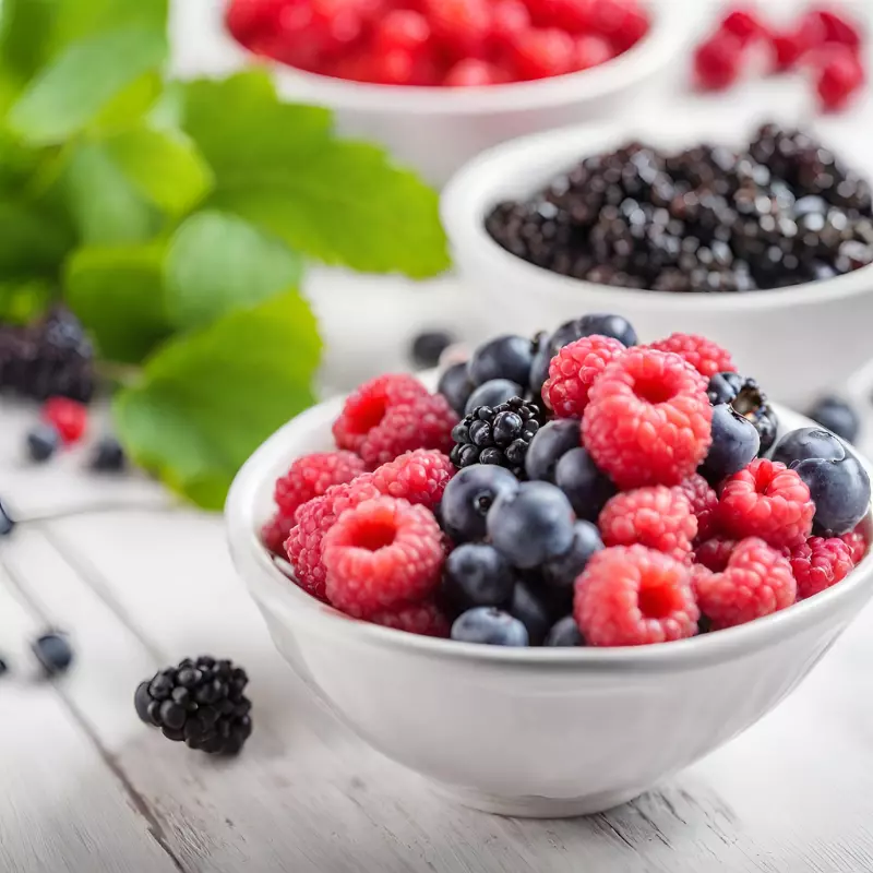 Mixed berries in a bowl with a background highlighting their health benefits.