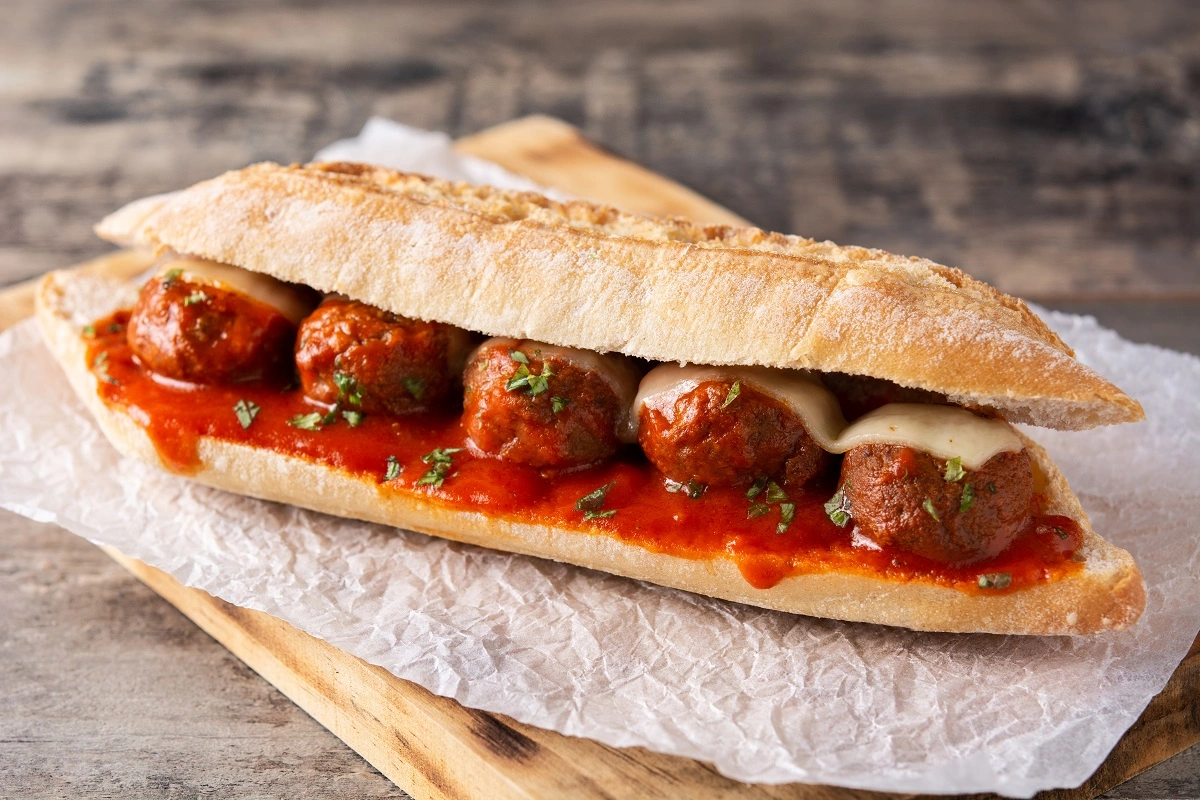 Assorted sides around a delicious meatball sub, representing perfect pairings.