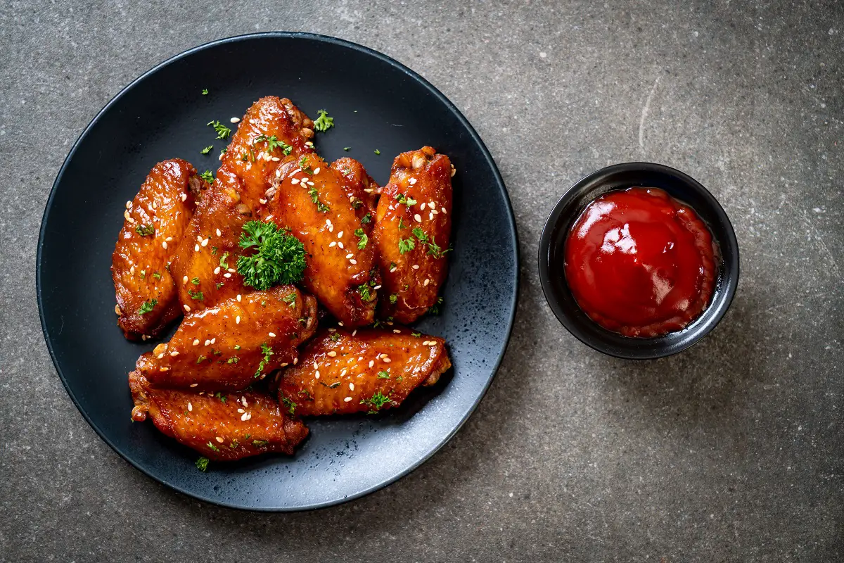 Cozy kitchen setting with a bowl of Honey Old Bay Wings on a wooden table.