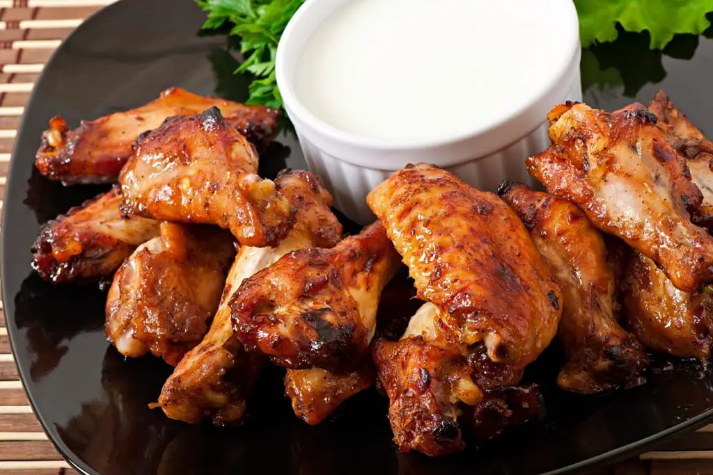 Platter of Honey Old Bay Wings garnished with fresh herbs