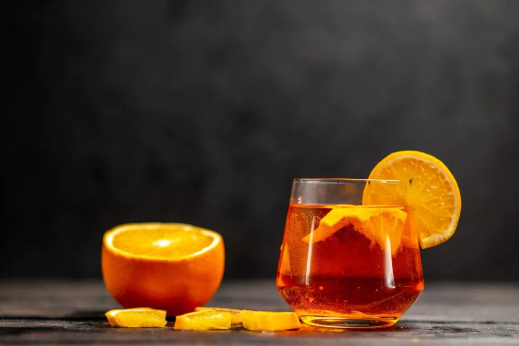 Orange Tea Shot in a clear glass with orange garnish and festive background.